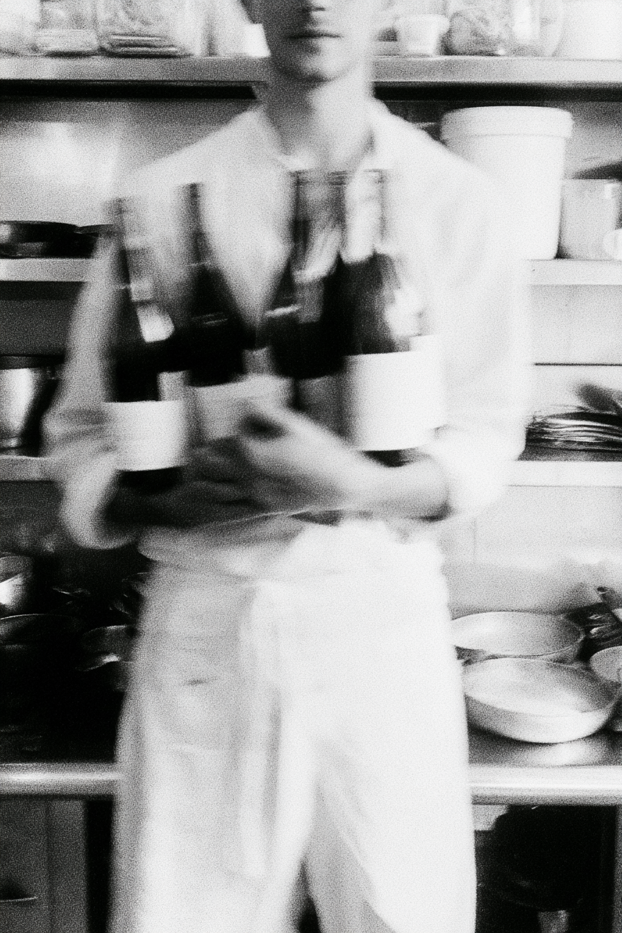 En cuisine, des bouteilles de vin plein les mains